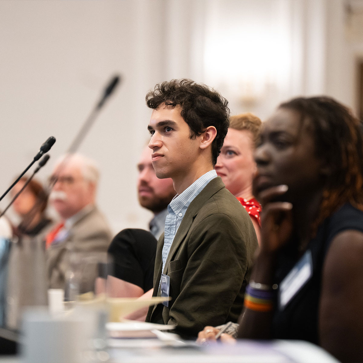 Jeune homme devant un micro pendant une réunion